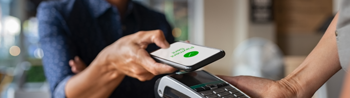 Person paying by phone on contactless reader